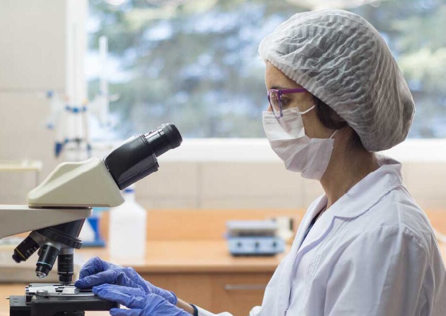 Cientista no laboratório Bionova da Nova do Brasil com um microscópio
